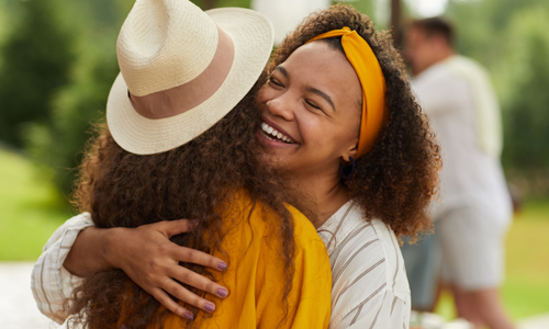 Two friends sharing a warm embrace outdoors